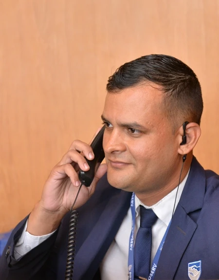 Colaborador da Proserv uniformizado com terno atendendo ligação, demonstrando escuta ativa, foco e profissionalismo em ambiente corporativo